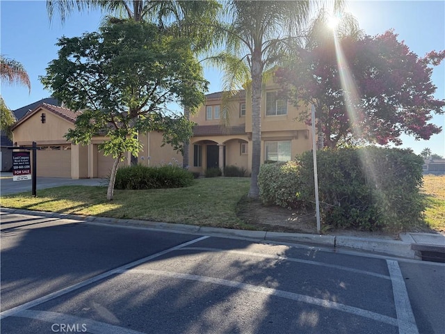 8185 Lakeshore Dr, Chowchilla, CA 93610 - mediterranean / spanish-style house featuring stucco siding, a front lawn, and an attached garage