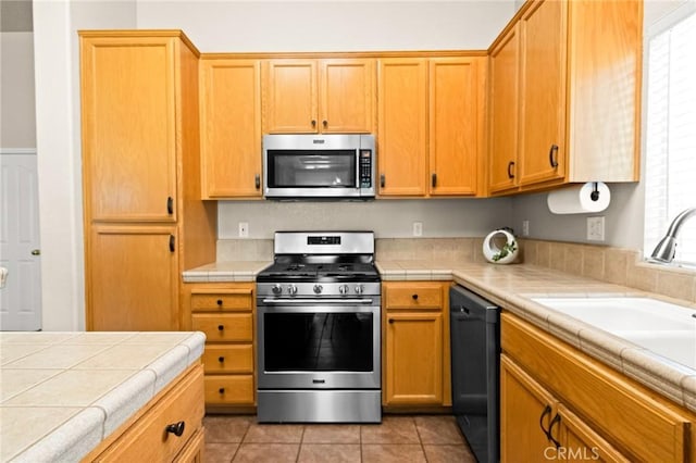 2092 Betsy Ross Ct, Atwater, CA 95301 - kitchen featuring appliances with stainless steel finishes, tile countertops, and light tile patterned floors