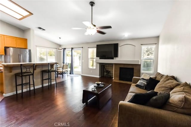 2092 Betsy Ross Ct, Atwater, CA 95301 - living area featuring vaulted ceiling, dark wood-style flooring, a ceiling fan, and a tiled fireplace