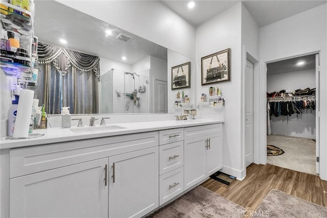 16614 Trailblazer Ave, Chino, CA 91708 - bathroom featuring double vanity, a stall shower, a spacious closet, wood finished floors, and recessed lighting