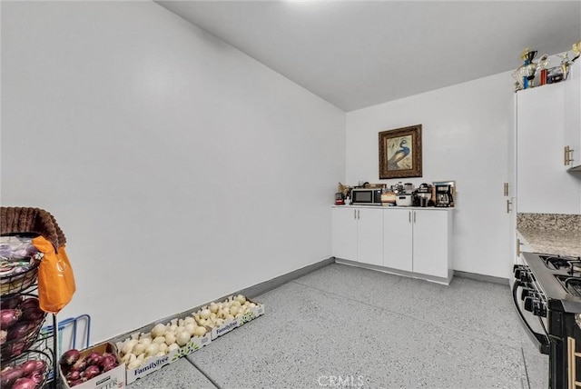 16614 Trailblazer Ave, Chino, CA 91708 - interior space with gas stove, white cabinetry, stainless steel microwave, light countertops, and dark speckled floor