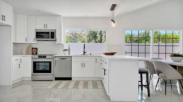 23231 Cheswald Dr, Laguna Niguel, CA 92677 - kitchen with appliances with stainless steel finishes, a peninsula, light countertops, white cabinets, and a kitchen bar