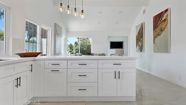 23231 Cheswald Dr, Laguna Niguel, CA 92677 - kitchen with vaulted ceiling, white cabinetry, light marble finish floors, pendant lighting, and light countertops