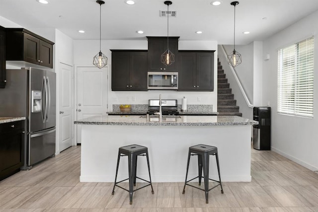 4192 Camino Campana, Oceanside, CA 92057 - kitchen with stainless steel appliances, a breakfast bar, recessed lighting, light stone counters, and a center island with sink