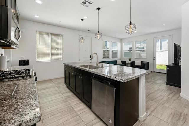 4192 Camino Campana, Oceanside, CA 92057 - kitchen featuring appliances with stainless steel finishes, recessed lighting, light stone countertops, hanging light fixtures, and an island with sink