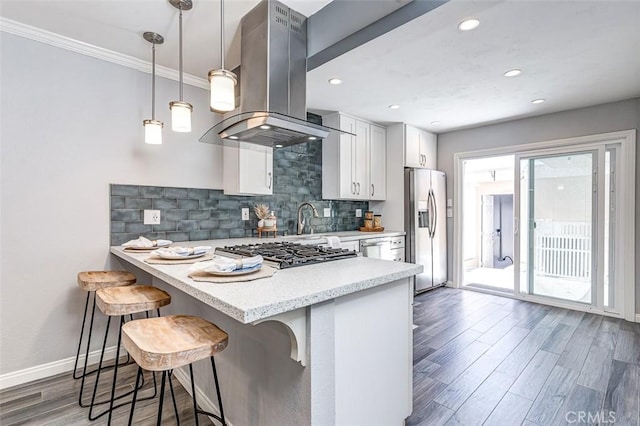 23113 Cherry Ave Unit 15, Lake Forest, CA 92630 - kitchen featuring appliances with stainless steel finishes, island exhaust hood, a kitchen breakfast bar, wood finished floors, and backsplash