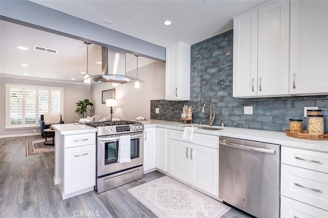 23113 Cherry Ave Unit 15, Lake Forest, CA 92630 - kitchen featuring stainless steel appliances, exhaust hood, a peninsula, white cabinetry, and backsplash