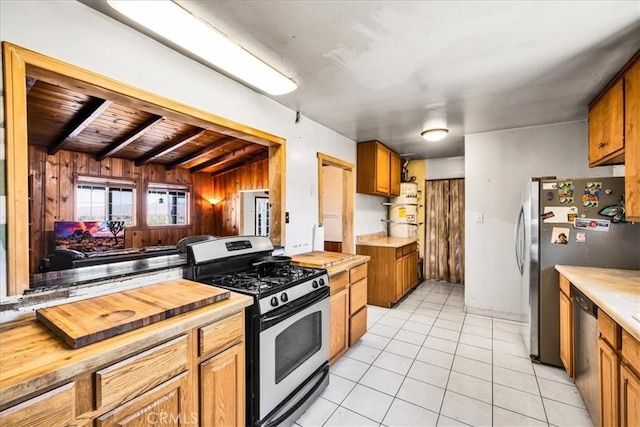 5177 Avenida Del Sol, Joshua Tree, CA 92252 - kitchen featuring stainless steel appliances, butcher block countertops, light tile patterned floors, wood walls, and brown cabinets