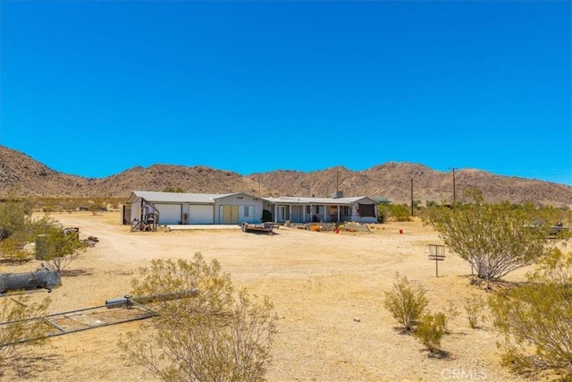 5177 Avenida Del Sol, Joshua Tree, CA 92252 - rear view of property featuring dirt driveway, a mountain view, an attached garage, and a view of rural / pastoral area