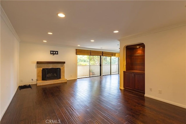 6242 Riviera Cir, Long Beach, CA 90815 - unfurnished living room featuring ornamental molding, wood finished floors, recessed lighting, a tiled fireplace, and arched walkways