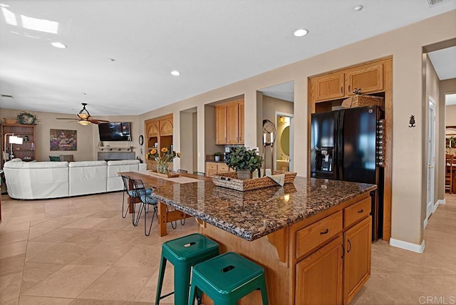 595 S Hidden Trails Rd, Escondido, CA 92027 - kitchen featuring recessed lighting, dark stone countertops, a kitchen bar, ceiling fan, and a kitchen island