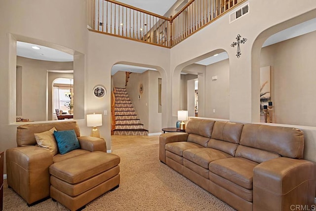 595 S Hidden Trails Rd, Escondido, CA 92027 - living area with arched walkways, carpet flooring, a towering ceiling, and stairs