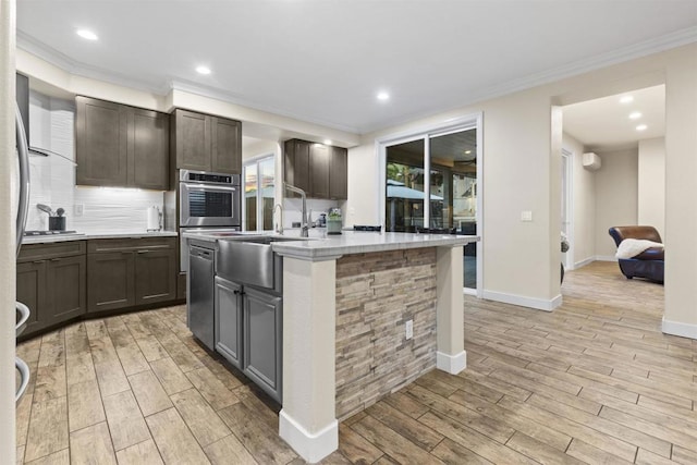 1209 Morgan Hill Dr, Chula Vista, CA 91913 - kitchen with light countertops, light wood-type flooring, crown molding, a kitchen island with sink, and decorative backsplash