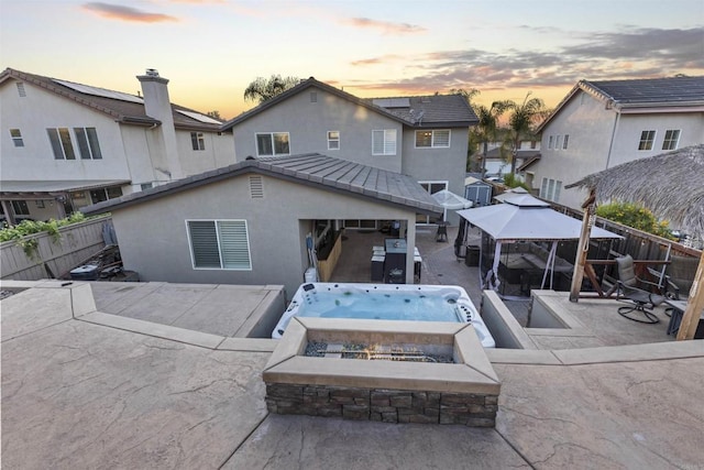 1209 Morgan Hill Dr, Chula Vista, CA 91913 - back of house at dusk with a gazebo, a fenced backyard, a patio, a hot tub, and stucco siding