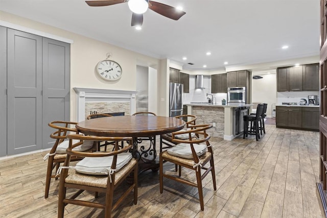 1209 Morgan Hill Dr, Chula Vista, CA 91913 - dining area featuring a stone fireplace, ceiling fan, light wood-style flooring, recessed lighting, and ornamental molding
