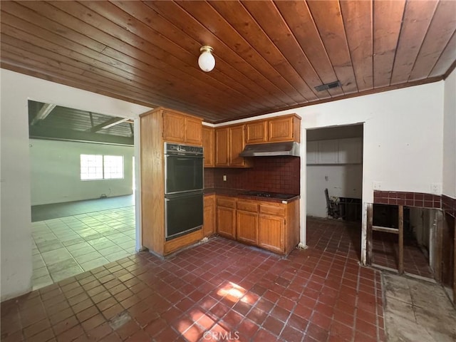 28869 Paradise Rd, Castaic, CA 91384 - kitchen with black appliances, under cabinet range hood, wood ceiling, dark tile patterned floors, and tasteful backsplash