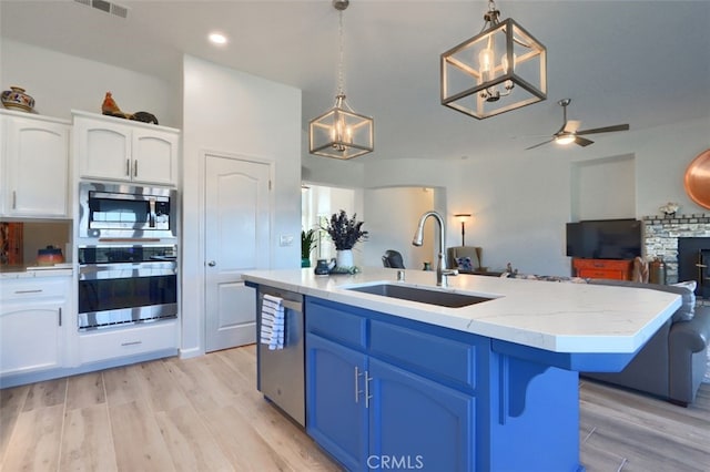 31008 Longview Ln E, Coarsegold, CA 93614 - kitchen with stainless steel appliances, white cabinetry, light wood finished floors, blue cabinetry, and open floor plan