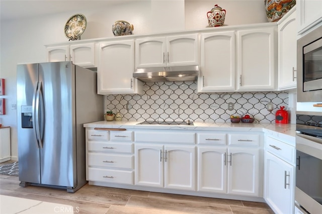 31008 Longview Ln E, Coarsegold, CA 93614 - kitchen featuring stainless steel appliances, under cabinet range hood, white cabinetry, light wood-type flooring, and backsplash