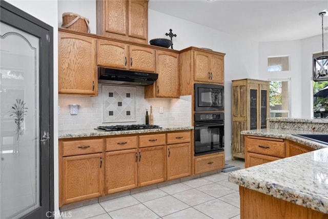 403 Stone Cross Dr, Bakersfield, CA 93312 - kitchen with black appliances, under cabinet range hood, tasteful backsplash, light tile patterned floors, and hanging light fixtures