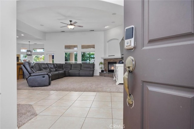 403 Stone Cross Dr, Bakersfield, CA 93312 - living area with light colored carpet, a ceiling fan, light tile patterned flooring, a glass covered fireplace, and plenty of natural light