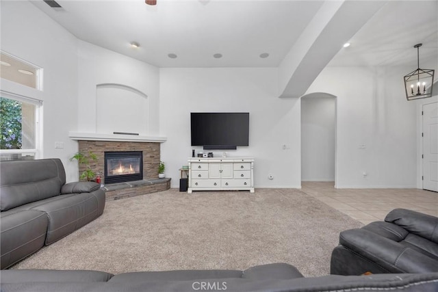 403 Stone Cross Dr, Bakersfield, CA 93312 - living area featuring a chandelier, a stone fireplace, tile patterned floors, and carpet flooring