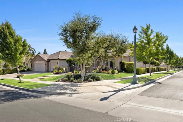 403 Stone Cross Dr, Bakersfield, CA 93312 - view of property hidden behind natural elements with an attached garage, stucco siding, driveway, a front lawn, and a tiled roof