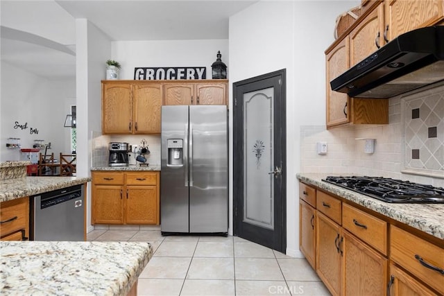 403 Stone Cross Dr, Bakersfield, CA 93312 - kitchen with stainless steel appliances, under cabinet range hood, light tile patterned floors, decorative backsplash, and arched walkways