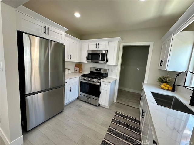 2209 W Glendon Way, Alhambra, CA 91803 - kitchen with appliances with stainless steel finishes, light stone counters, white cabinets, light wood-style floors, and recessed lighting
