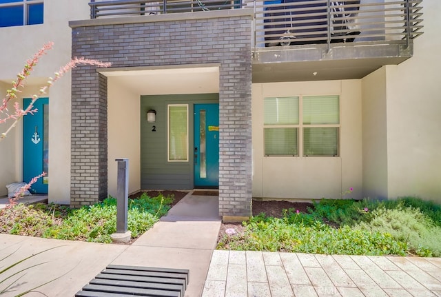 1905 Soho Ln Unit 2, Chula Vista, CA 91915 - view of exterior entry featuring a balcony, stucco siding, and brick siding