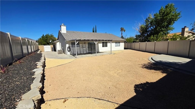37432 Whitehall Ln, Palmdale, CA 93550 - back of property with a fenced backyard, a patio area, a chimney, and stucco siding