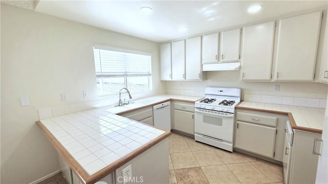 37432 Whitehall Ln, Palmdale, CA 93550 - kitchen with white appliances, under cabinet range hood, a peninsula, tile countertops, and white cabinetry