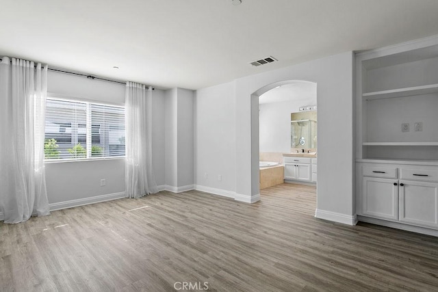 5612 Sprague Ave, Cypress, CA 90630 - unfurnished living room featuring arched walkways, wood finished floors, and built in features
