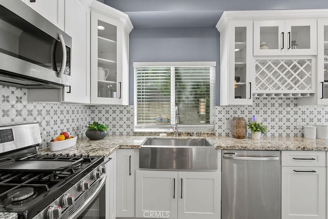 5612 Sprague Ave, Cypress, CA 90630 - kitchen with stainless steel appliances, white cabinetry, tasteful backsplash, and light stone countertops