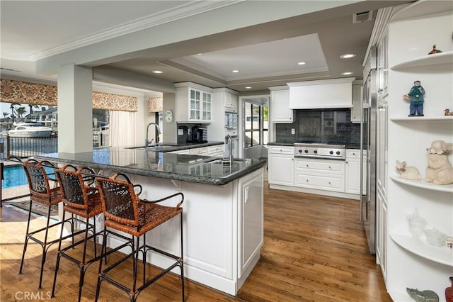 3871 Mistral Dr, Huntington Beach, CA 92649 - kitchen with stovetop, white cabinetry, a raised ceiling, dark wood-style floors, and ornamental molding