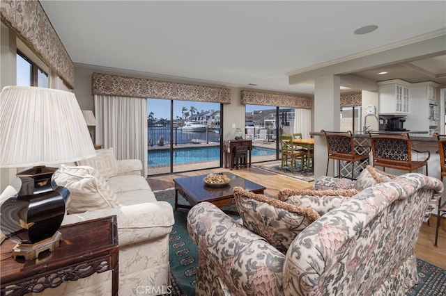 3871 Mistral Dr, Huntington Beach, CA 92649 - living room featuring healthy amount of natural light, wood finished floors, a water view, and ornamental molding