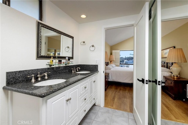 3871 Mistral Dr, Huntington Beach, CA 92649 - ensuite bathroom featuring vaulted ceiling, double vanity, wood finished floors, and recessed lighting