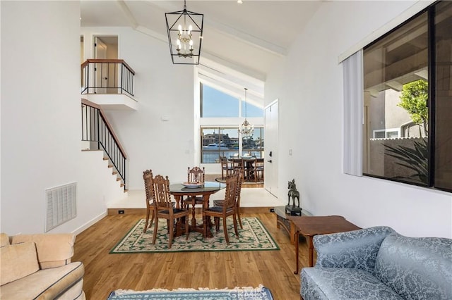 3871 Mistral Dr, Huntington Beach, CA 92649 - dining space with a chandelier, plenty of natural light, wood finished floors, stairway, and high vaulted ceiling