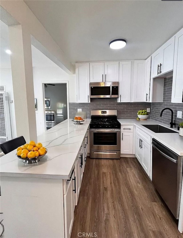 10802 Palma Vista Ave, Garden Grove, CA 92840 - kitchen with appliances with stainless steel finishes, a peninsula, dark wood-style floors, and tasteful backsplash
