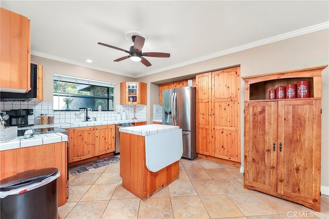 29639 Delphinium Ave, Canyon Country, CA 91387 - kitchen featuring tile countertops, stainless steel appliances, a ceiling fan, decorative backsplash, and ornamental molding