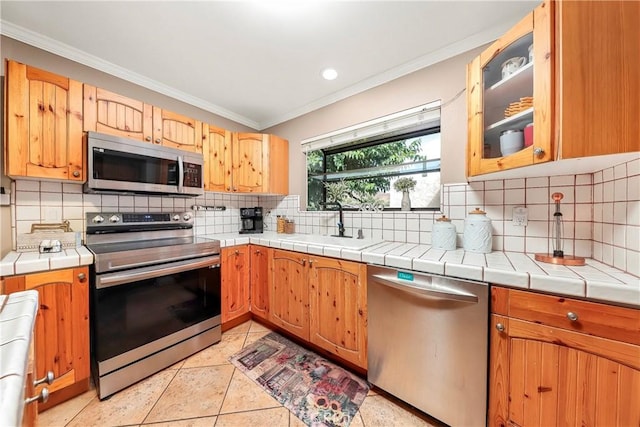 29639 Delphinium Ave, Canyon Country, CA 91387 - kitchen featuring stainless steel appliances, crown molding, backsplash, glass insert cabinets, and recessed lighting