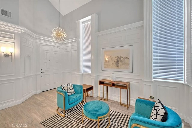 16549 Celadon Ct, Chino Hills, CA 91709 - sitting room with a decorative wall, light wood-style floors, a chandelier, lofted ceiling, and a wainscoted wall
