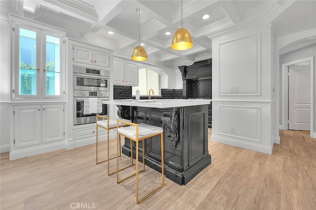 16549 Celadon Ct, Chino Hills, CA 91709 - kitchen featuring double oven, light countertops, an island with sink, coffered ceiling, and beam ceiling