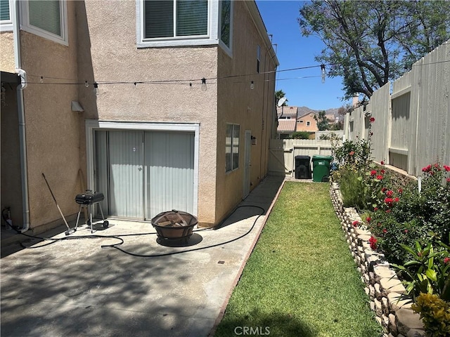 10600 Silverleaf Cir, Moreno Valley, CA 92557 - view of property exterior featuring an outdoor fire pit, stucco siding, a fenced backyard, and a patio