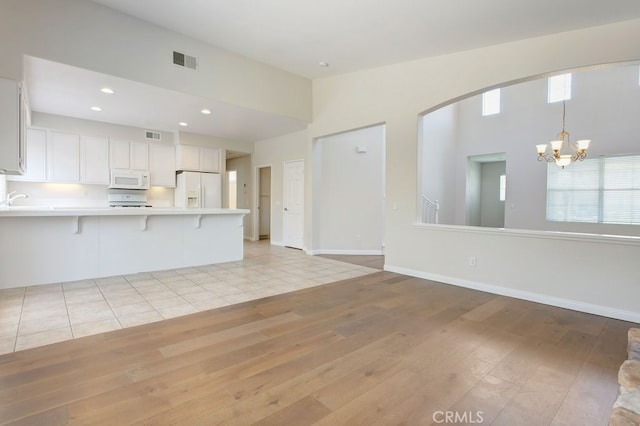 3450 Lake Park Ave, Fallbrook, CA 92028 - unfurnished living room with light wood finished floors, a chandelier, arched walkways, and recessed lighting