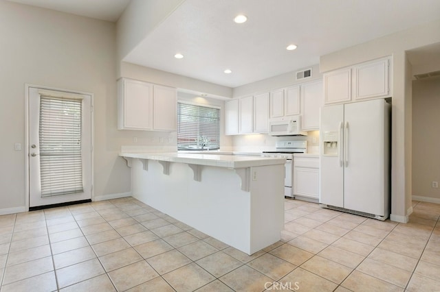 3450 Lake Park Ave, Fallbrook, CA 92028 - kitchen with white appliances, a peninsula, light countertops, white cabinets, and a kitchen bar