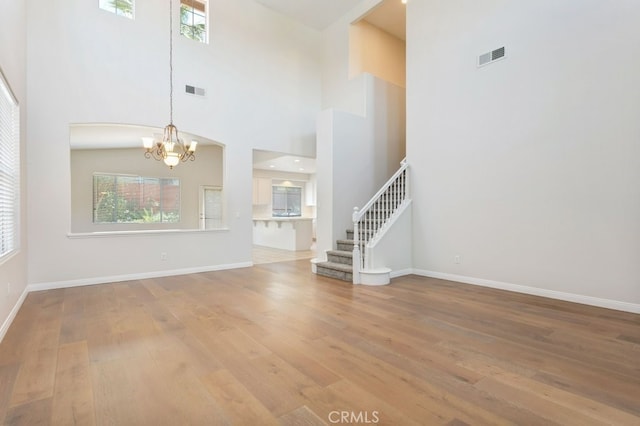 3450 Lake Park Ave, Fallbrook, CA 92028 - unfurnished living room with a chandelier, wood finished floors, stairway, and a towering ceiling