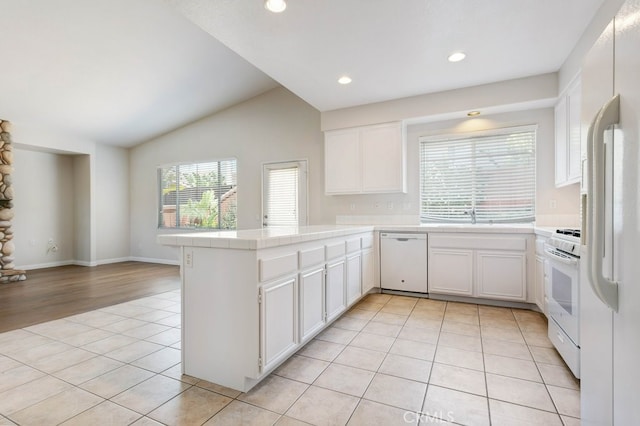 3450 Lake Park Ave, Fallbrook, CA 92028 - kitchen featuring white appliances, a peninsula, light tile patterned flooring, tile countertops, and lofted ceiling