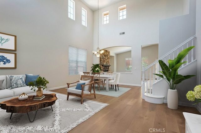 3450 Lake Park Ave, Fallbrook, CA 92028 - living room featuring arched walkways, wood finished floors, a high ceiling, a chandelier, and stairway