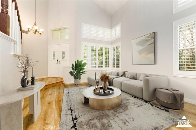 23609 Wilmington Ct, Valencia, CA 91354 - living room with a chandelier, high vaulted ceiling, and light wood-style floors