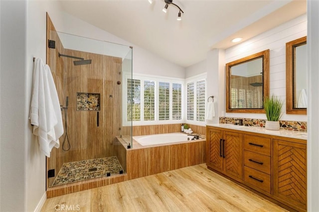 23609 Wilmington Ct, Valencia, CA 91354 - bathroom featuring a garden tub, walk in shower, vaulted ceiling, double vanity, and wood finished floors